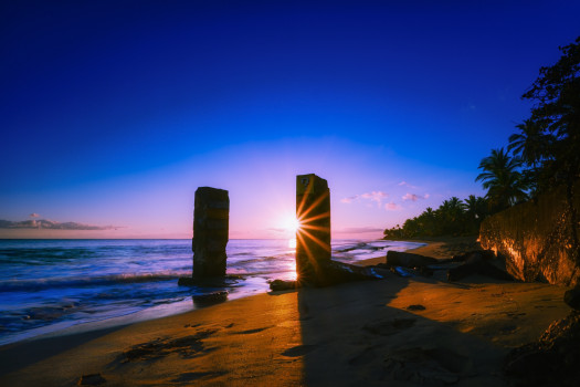 Rising into the Mystical: Tropical Beach Sunrise Illuminates the Ocean Surface and the Mysterious Pillars That Rise from Below, in this Acrylic Print